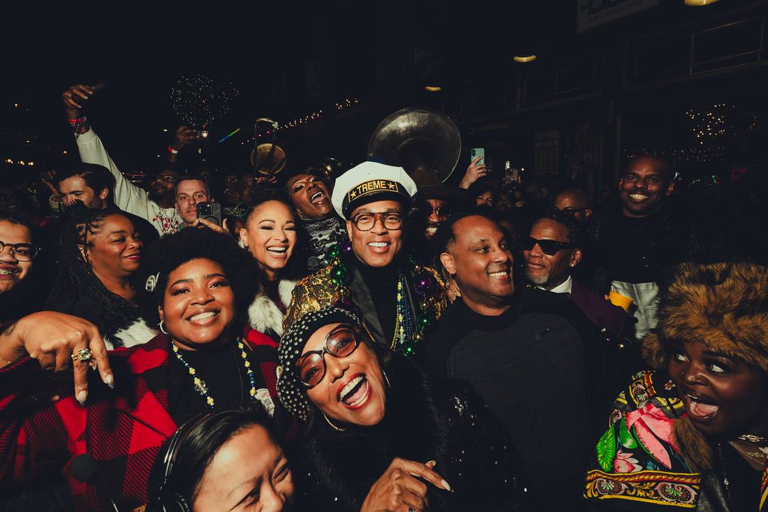 Don surrounded by guests and a brass band